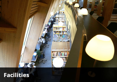 a view of the faculty library taken from the top floor down towards the racks and computer desks on the ground floor